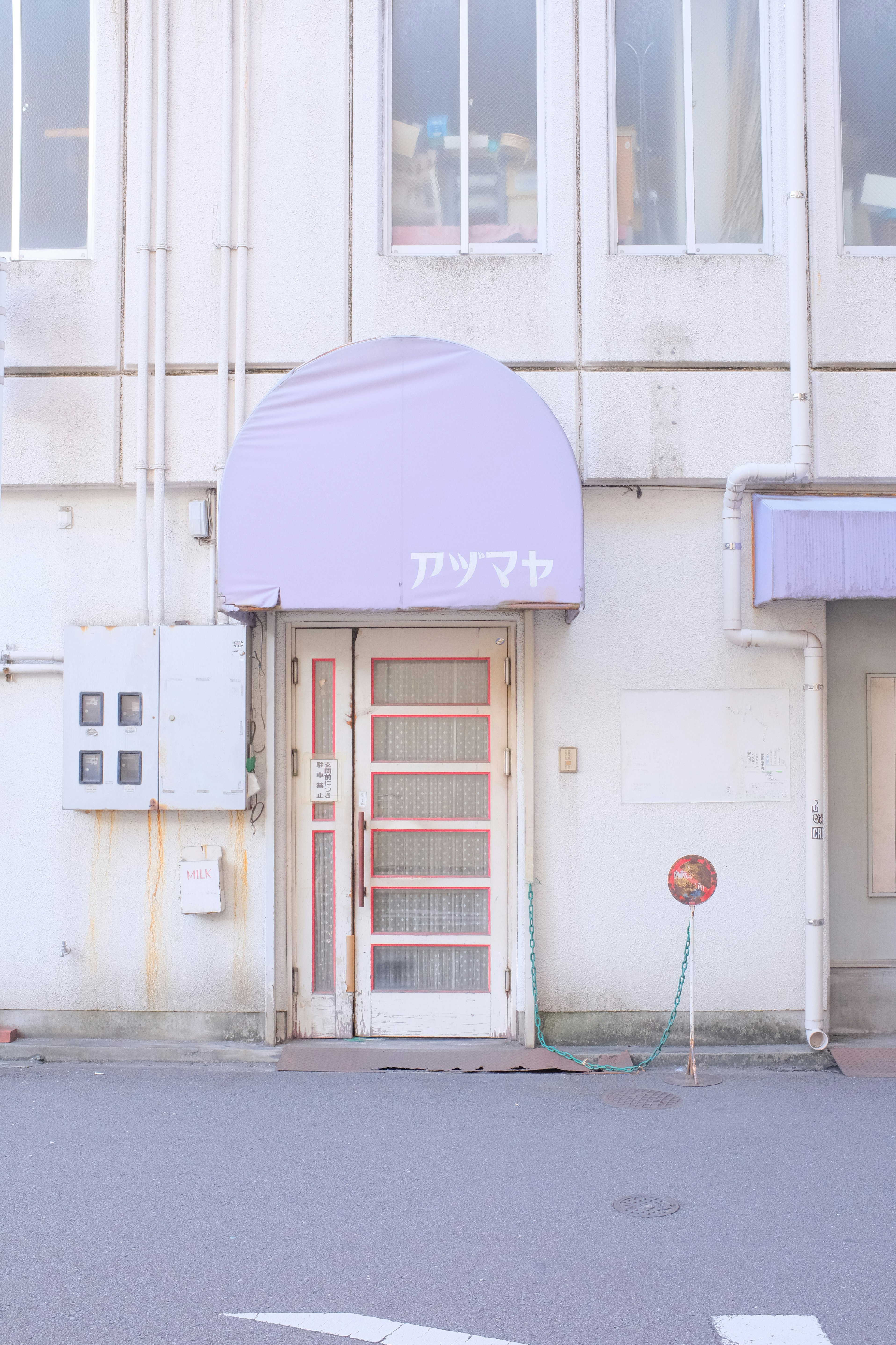 white concrete building with red metal doors